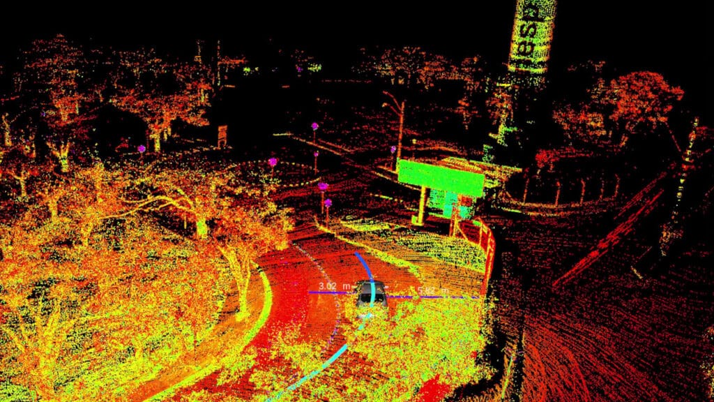 Imagem gerada por LiDAR mostrando uma rua curva com árvores ao redor, um carro no centro e medições de distância destacadas em metros. A cena é composta por pontos coloridos representando o ambiente urbano em detalhes.