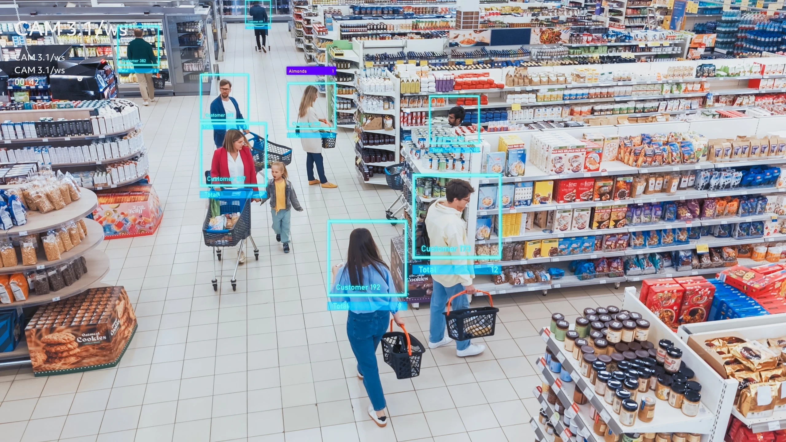 Supermercado visto de cima, mostrando vários clientes caminhando entre corredores de produtos. Alguns empurram carrinhos e outros carregam cestas de compras. Caixas e prateleiras estão cheias de alimentos e itens variados. Ao redor das pessoas, há molduras digitais destacando cada cliente, simulando uma tecnologia de monitoramento por inteligência artificial. Supermarket viewed from above, showing multiple customers walking through aisles filled with products. Some people are pushing shopping carts while others carry shopping baskets. Shelves and displays are stocked with various food items. Around each person, digital frames highlight the customers, simulating artificial intelligence monitoring technology.