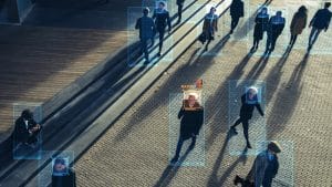 Vista aérea de vigilância por IA em uma praça urbana, mostrando pessoas com caixas de detecção facial e um 'MATCH' vermelho destacado no centro. Conceitos: vigilância por video, video surveillance, falso positivo, false positive.